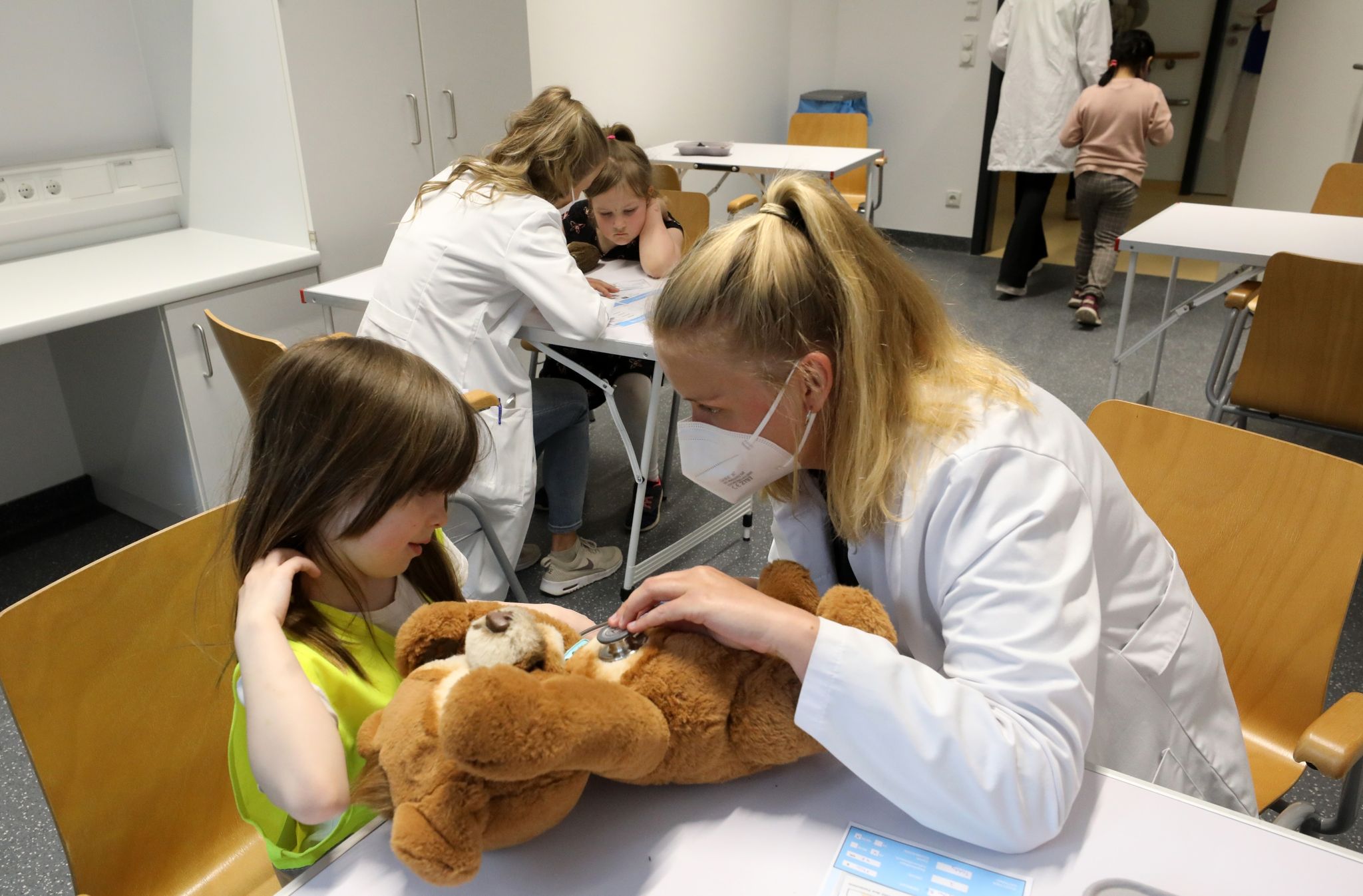 Nach der Wiedereröffnung des Teddybärkrankenhauses an der Universitätsmedizin empfängt Anna Rautmann, Medizinstudentin, den Teddy einer kleinen Besucherin.