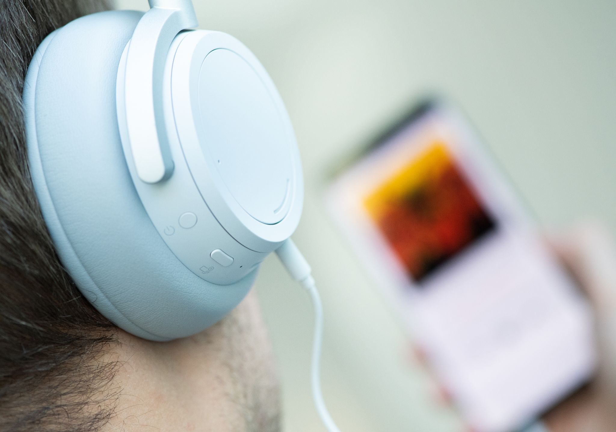 Ein junger Mann hört mit Kopfhörern Musik. Doch Kopfhörer bergen Risiken, vor allem bei Dauerbeschallung in hoher Lautstärke.