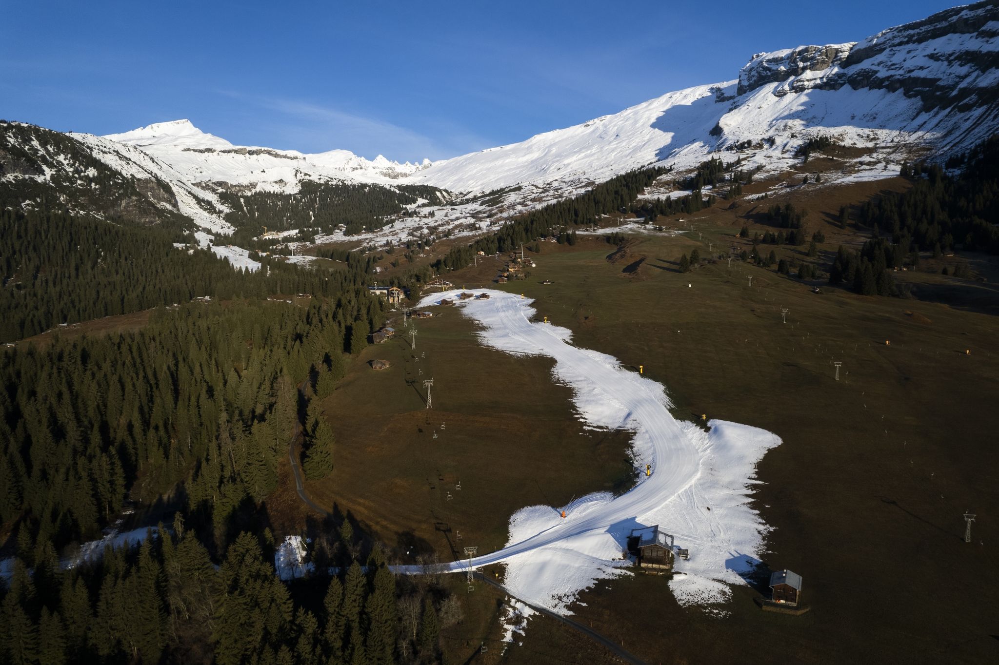Blick auf die Talabfahrt aus Kunstschnee in Graubünden. In vielen Wintersportgebieten ist es derzeit eher grün statt weiß.