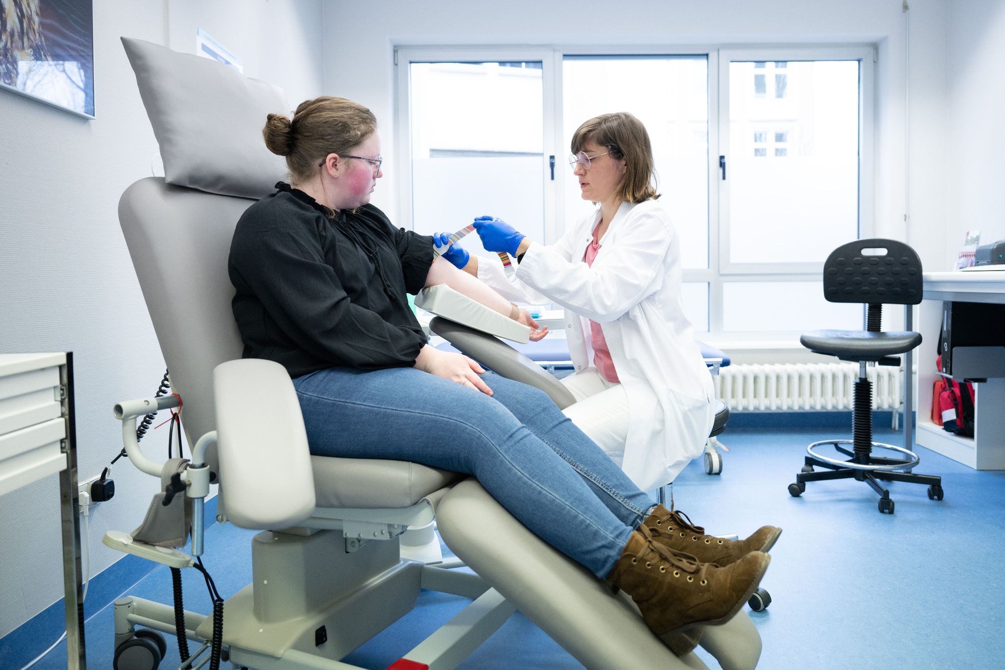 Katharina Egger-Heidrich (r), Fachärztin Onkologie, bereitet die Patientin Michelle Müller im Nationalen Centrum für Tumorerkrankungen am Universitätsklinikum auf eine Blutabnahme vor.