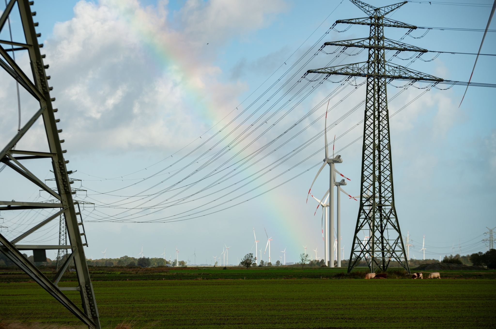 Ein Regenbogen zwischen Hochspannungsmasten und Windrädern in Schleswig-Holstein. Die für die Energiewende wichtige Westküstenleitung von der dänischen Grenze bis Brunsbüttel hat ihren Betrieb aufgenommen.