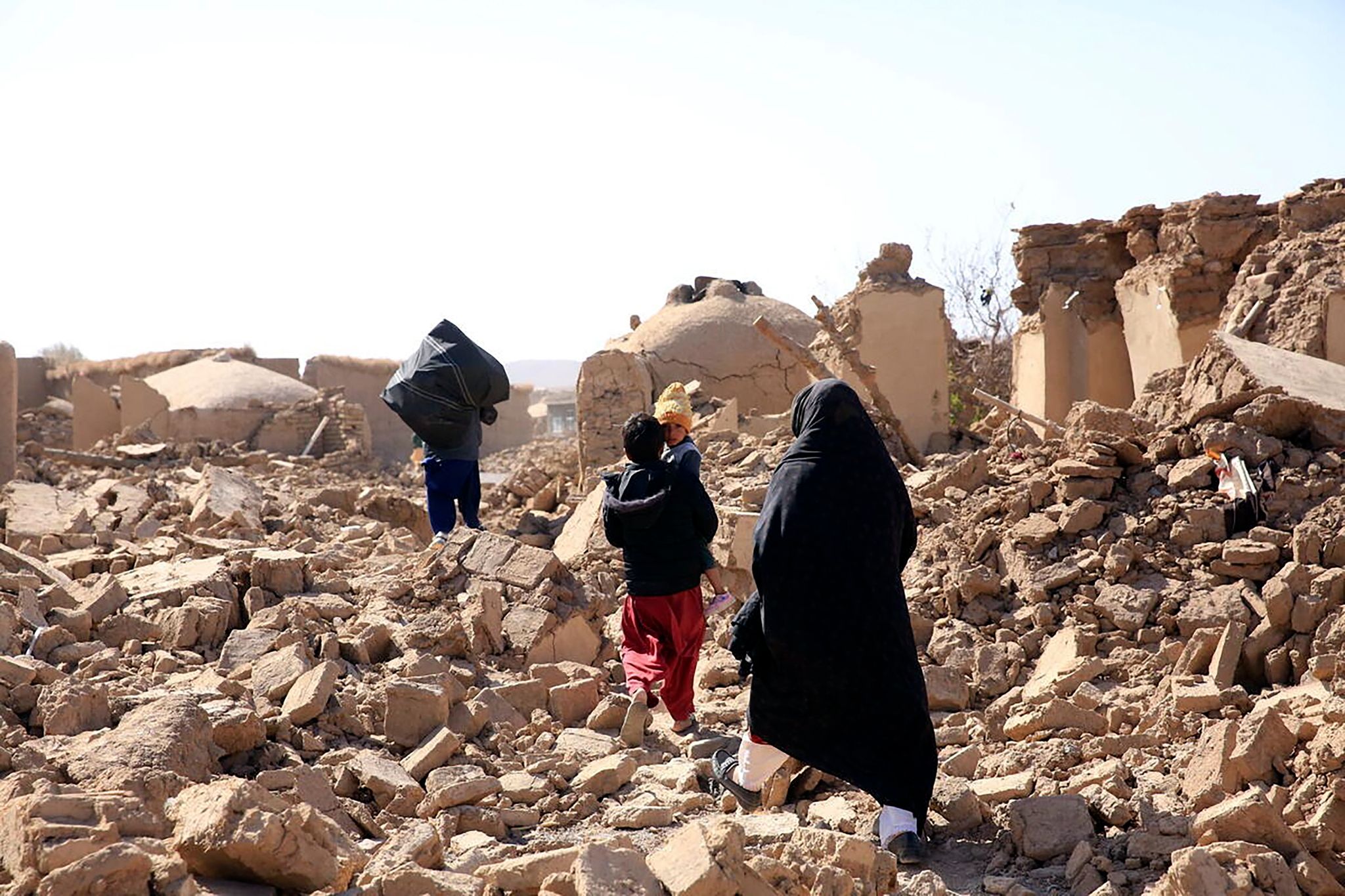 Menschen laufen über die Trümmer nach einem starken Erdbeben in der Provinz Herat im Westen Afghanistans.