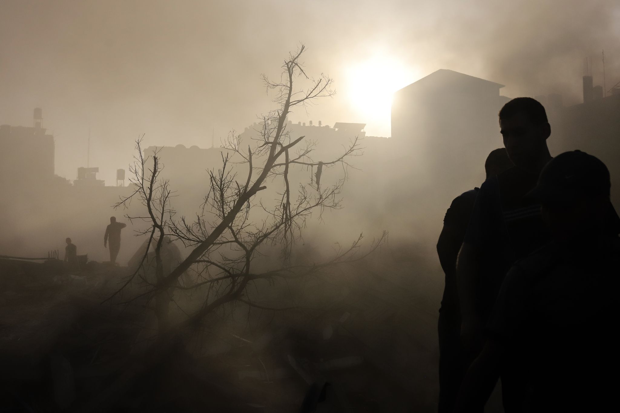Nach einem Luftangriff auf Gaza-Stadt scheint die Sonne durch das staubige und zerstörte Gebiet.