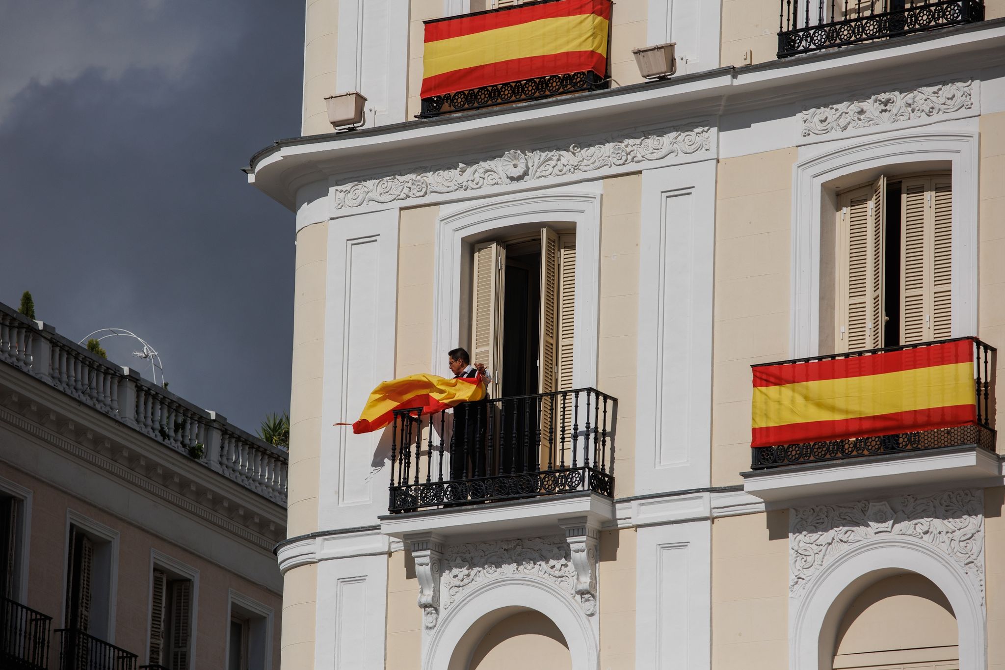 Die Vorbereitungen laufen: Eine Person hängt eine spanische Flagge an einem Balkon auf. Morgen, an ihrem 18. Geburtstag, soll die spanische Thronfolgerin Leonor Eid auf die Verfassung ablegen.