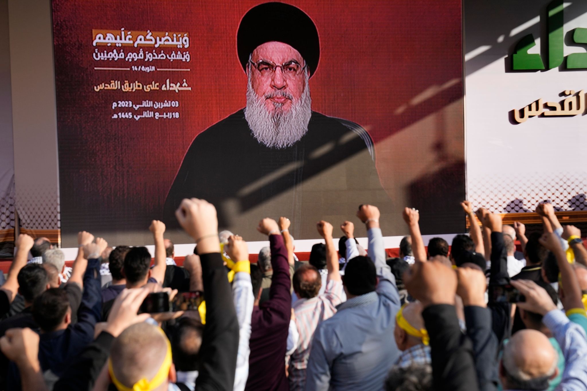 Anhänger der vom Iran unterstützten Hisbollah erheben in Beirut ihre Fäuste und jubeln, als Hisbollah-Führer Hassan Nasrallah während einer Kundgebung zum Gedenken an in den vergangenen Wochen getötete Hisbollah-Kämpfer über eine Videoverbindung erscheint.