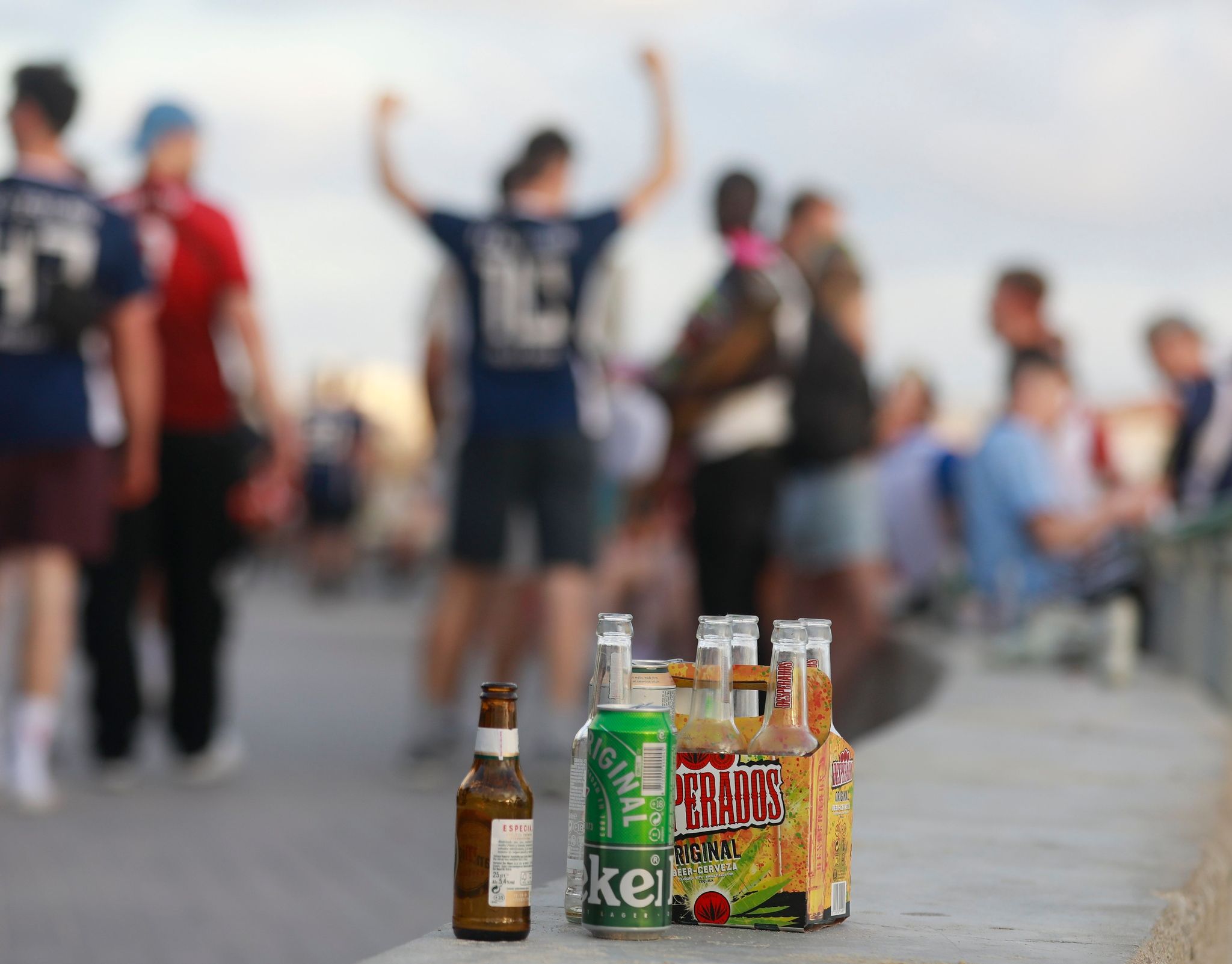 Menschen haben sich am Abend an der Promenade am Strand von Arenal versammelt und trinken Alkohol.