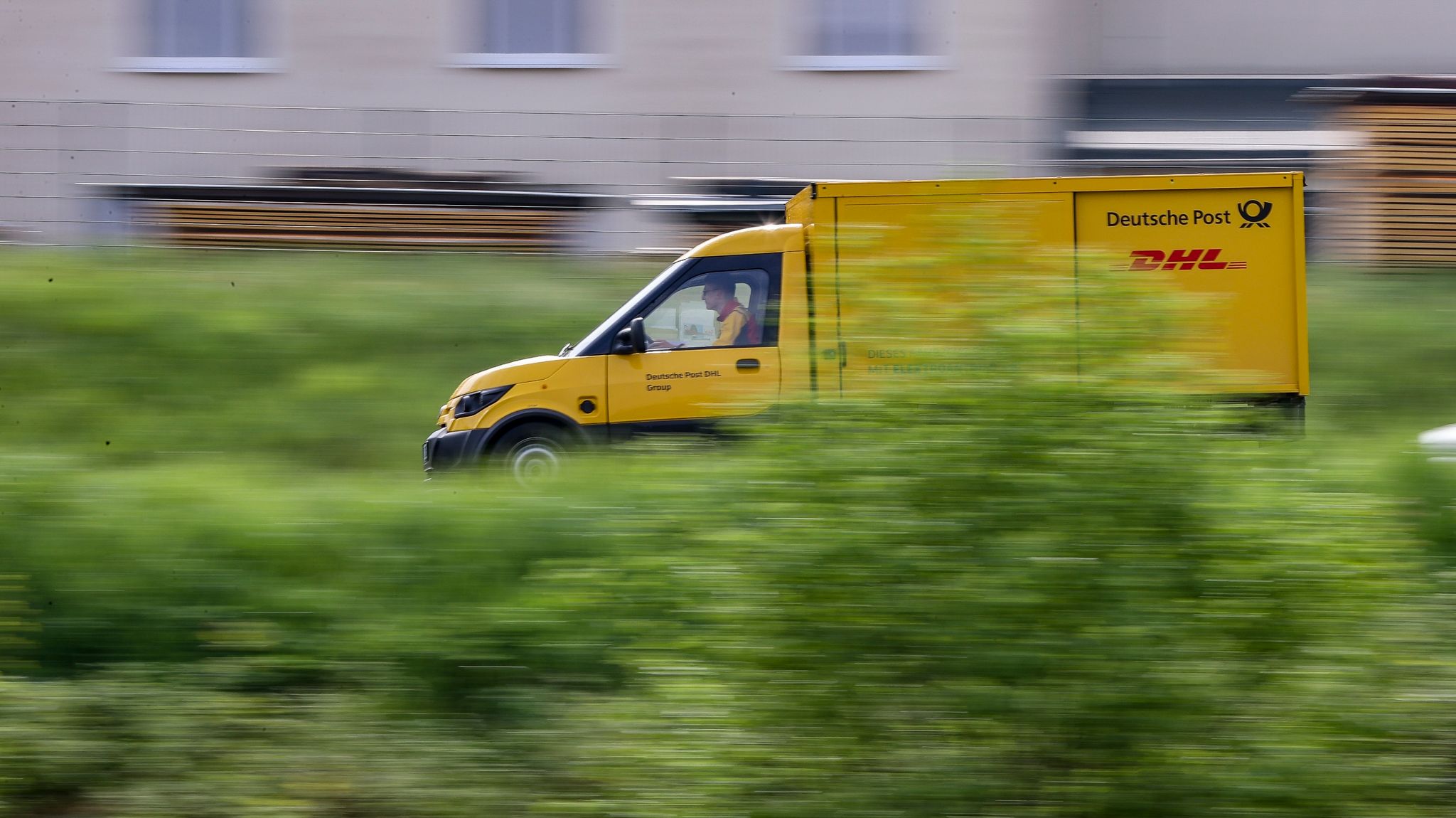 Ein Zusteller des Post-Konzerns DHL stellt mit einem elektrisch betriebenen Fahrzeug (Streetscooter) Post zu.