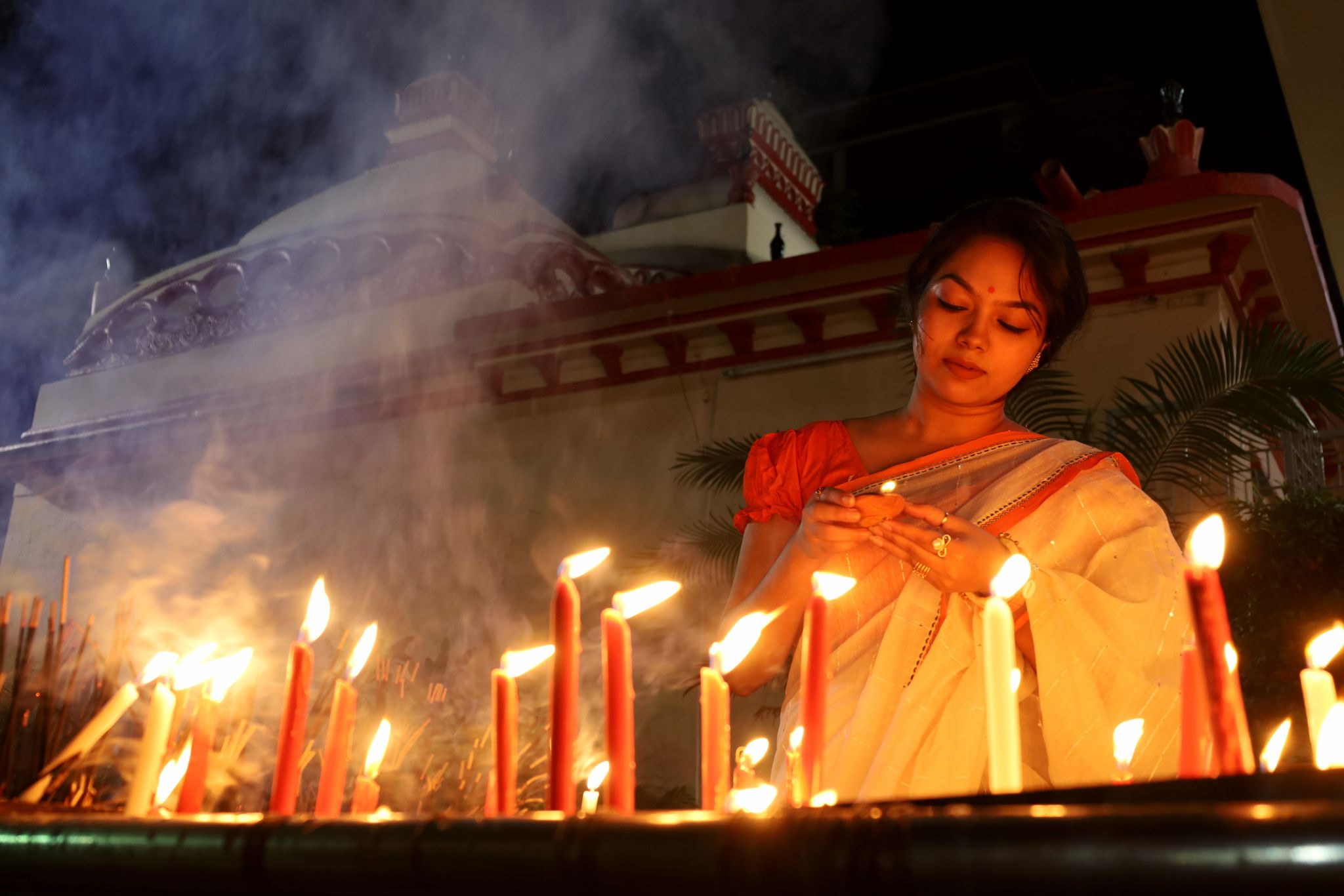 Das Lichterfest Diwali ist eines der wichtigsten Feste im Hinduismus. Eine Gläubige zündet im Dhakeschwari-Tempel in Bangladesch mehrere Kerzen an. Traditionell wird auch mit Weihrauch und Blumen gefeiert.