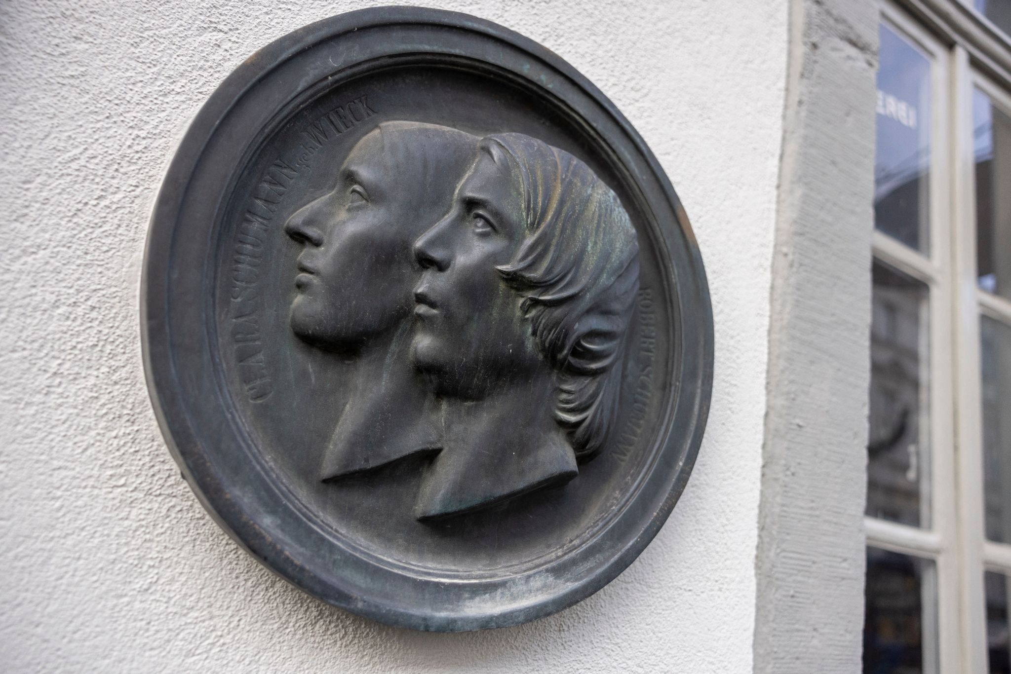 An der Fassade des Schumann-Hauses sind die Portraits aus Eisenguss von Clara und Robert Schumann angebracht.