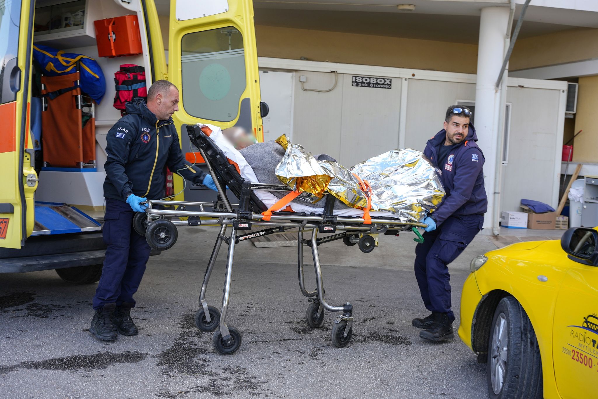 Sanitäter verlegen einen Überlebenden des Schiffsunglücks in ein Krankenhaus auf Lesbos.