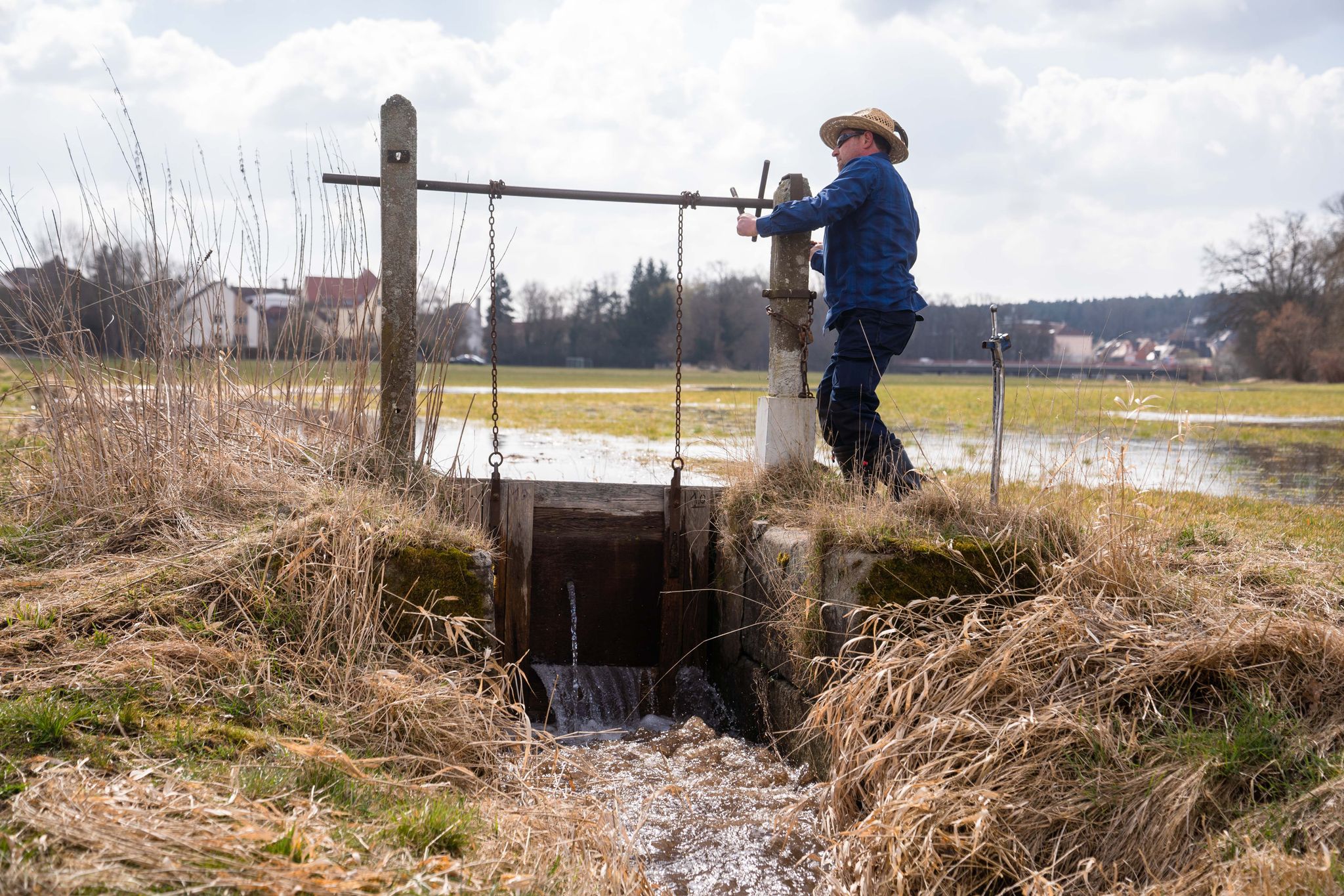 Der Wässerer Jürgen Zwingel öffnet eine Schleuse eines Wässergrabens im Ortsteil Reichelsdorf: Die Traditionelle Wiesenbewässerung ist von der Unesco zum immateriellen Kulturerbe ernannt worden.