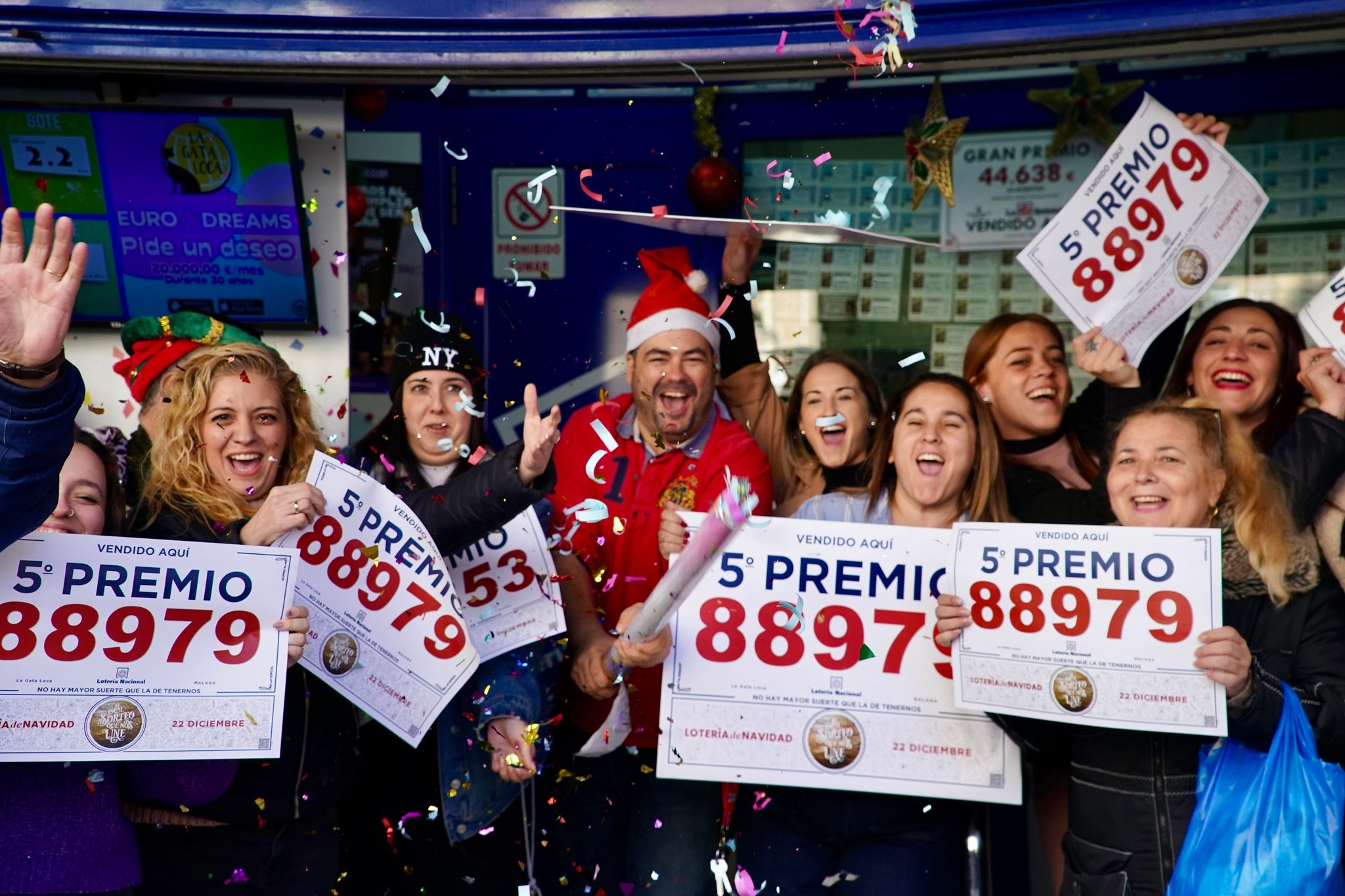 Gewinner der Weihnachtslotteriepreise feiern vor einer Lottoannahmestelle in Málaga.