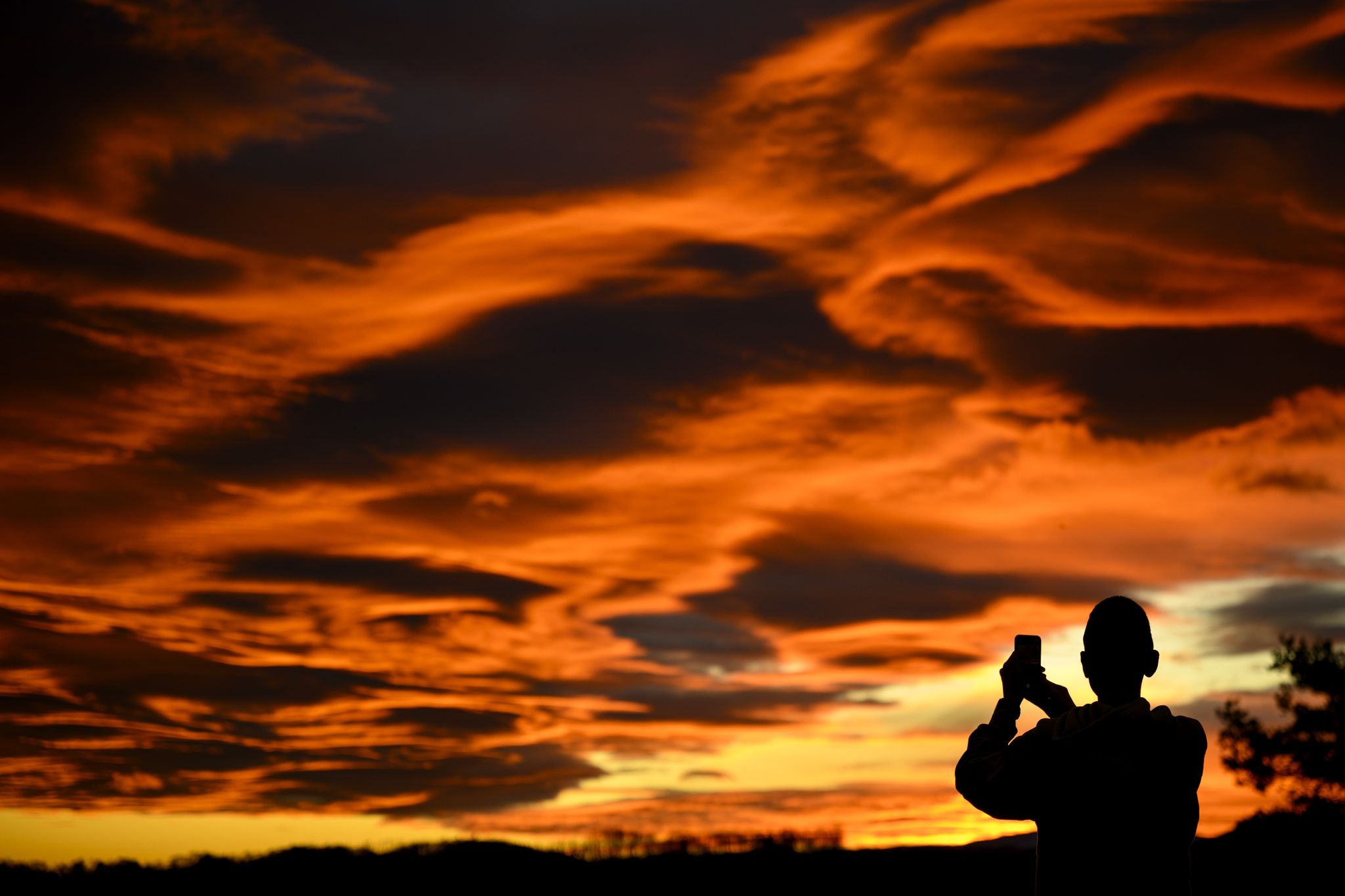 Das Naturschauspiel festhalten: Ein Mann fotografiert einen Sonnenuntergang.