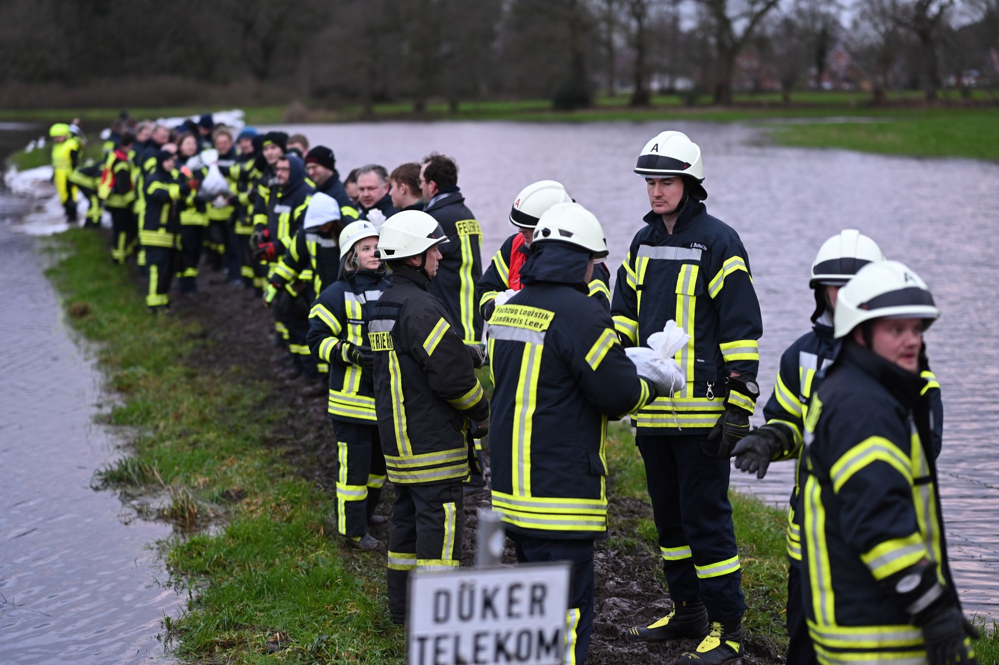 Gemeinschaftlicher Einsatz: Mit Sandsäcken versuchen Feuerwehrmänner die Ortschaft Langholt in Niedersachsen zu sichern, nachdem das Hochwasser von einem Nebenfluss der Leda über die Deiche trat.