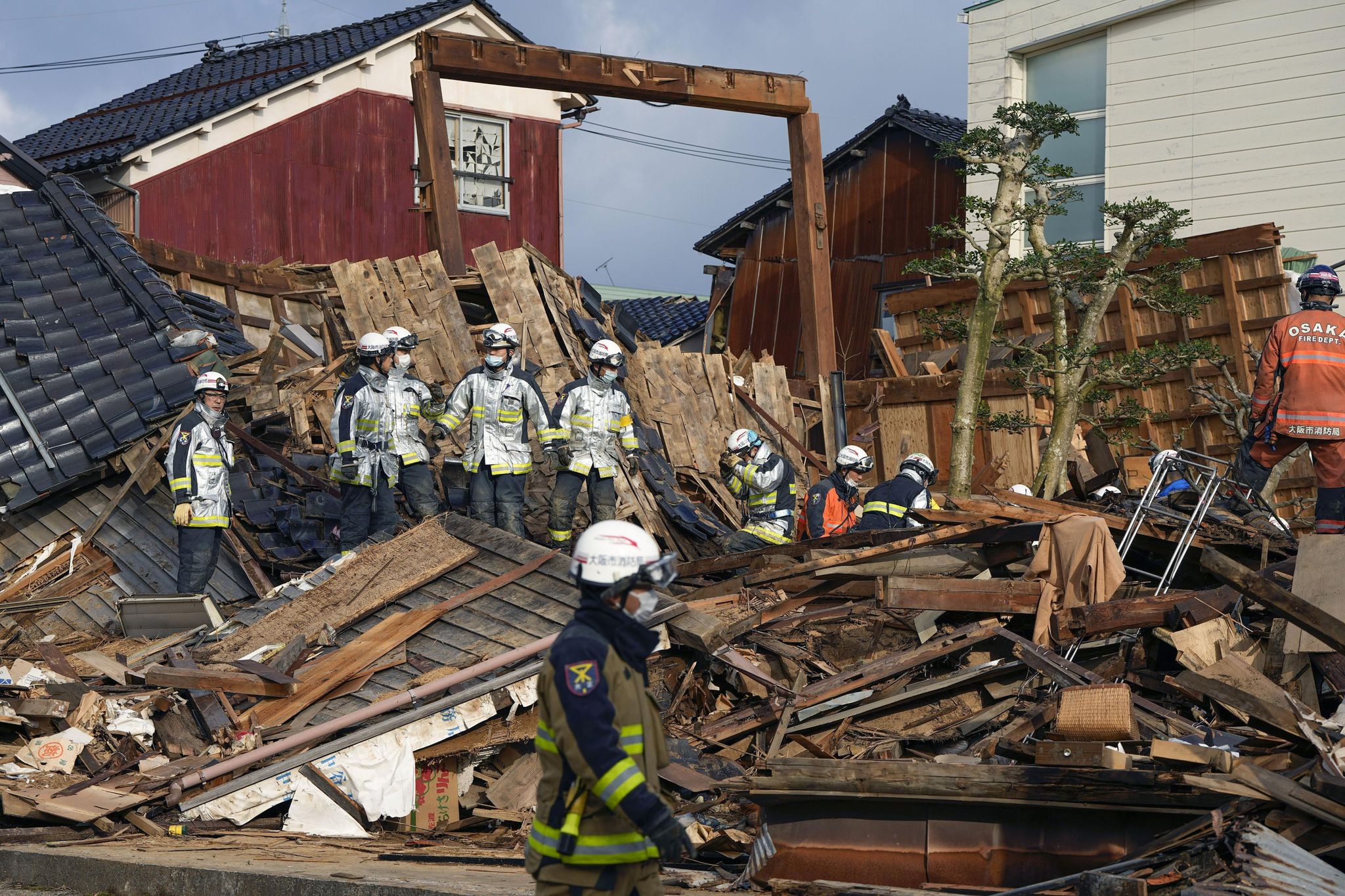 Rettungskräfte arbeiten an einem eingestürzten Gebäude in Wajima.