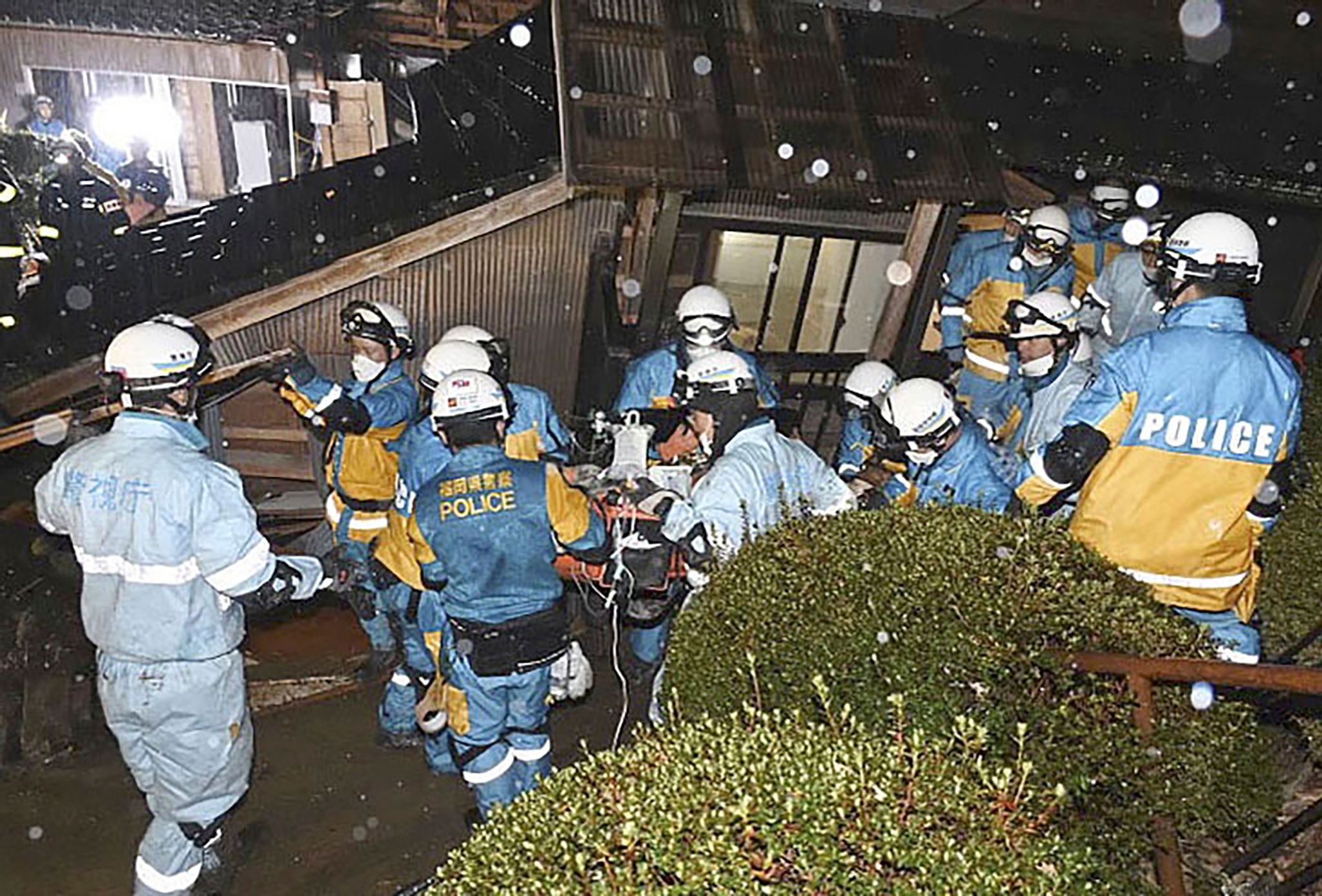Polizisten retten im japanischen Suzu eine Frau aus einem eingestürzten Haus.
