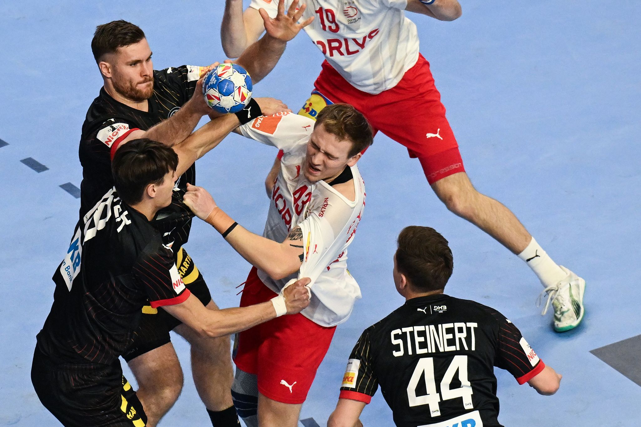 Dänemarks Simon Pytlick (M) wird von der deutschen Deckung attackiert. Das Deutsche Team muss sich im Halbfinale der Handball-EM in Köln gegen Dänemark geschlagen geben.
