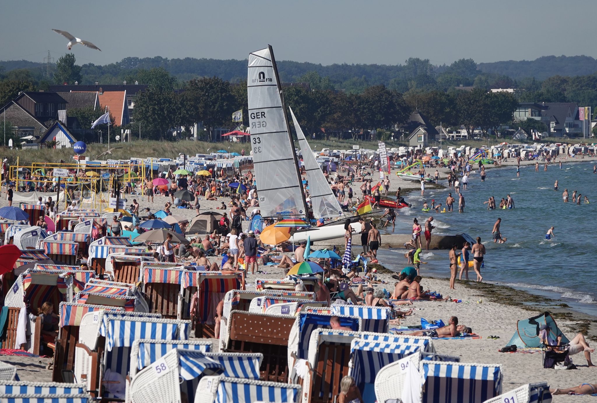 Menschen genießen das Sonnenwetter am Strand der Ostsee.