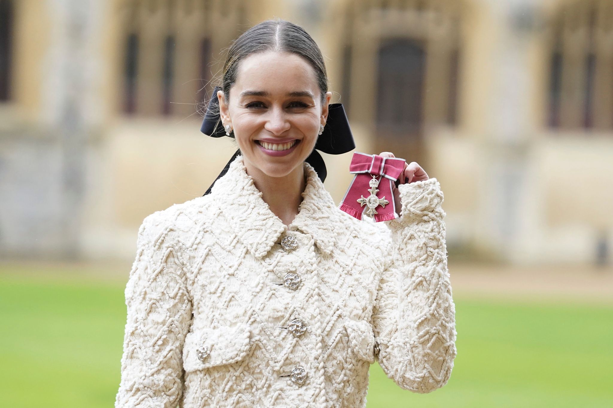 Emilia Clarke zeigt ihren Orden, nachdem sie und ihre Mutter von Prinz William auf Schloss Windsor zu Mitgliedern des Ordens des Britischen Empire ernannt wurden.